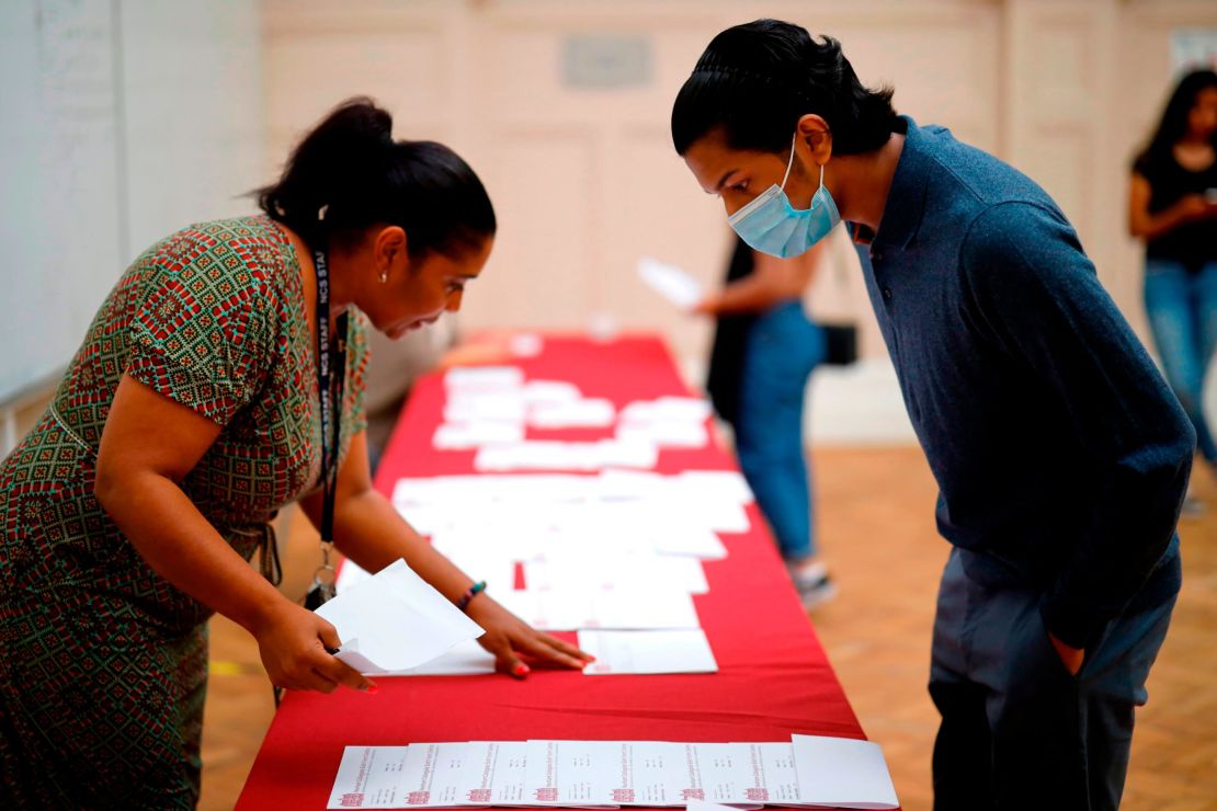 A-level students at Newham Collegiate Sixth Form in east London queue to receive their exam results on August 13, 2020. 