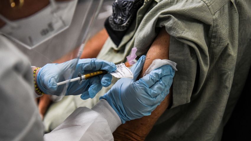 Thomas Hansler, 54, receives a COVID-19 vaccination from Yaquelin De La Cruz at the Research Centers of America in Hollywood, Florida on August 13, 2020. (Photo by CHANDAN KHANNA / AFP) (Photo by CHANDAN KHANNA/AFP via Getty Images)