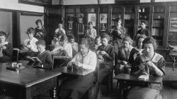 Portrait of deaf students in their classroom at Alexander Graham Bell School, 3730 North Oakley in the North Center community area, Chicago, Illinois, 1918. The boys in the photo read while the girls knit. (Photo by Chicago Sun-Times/Chicago Daily News collection/Chicago History Museum/Getty Images)