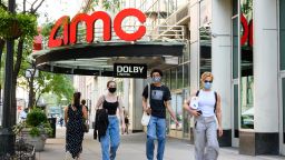 People wear protective face masks outside the AMC 34th Street 14 movie theater as the city continues Phase 4 of re-opening following restrictions imposed to slow the spread of coronavirus on July 31, 2020 in New York City. The fourth phase allows outdoor arts and entertainment, sporting events without fans and media production. (Photo by Noam Galai/Getty Images)