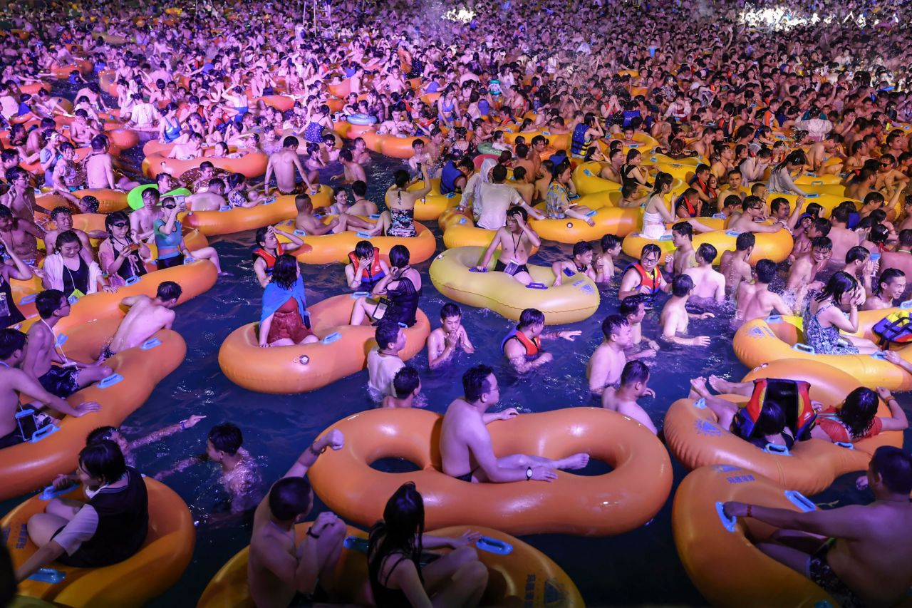People enjoy themselves on floating tubes in a crowded pool at the Wuhan Maya Beach Water Park.