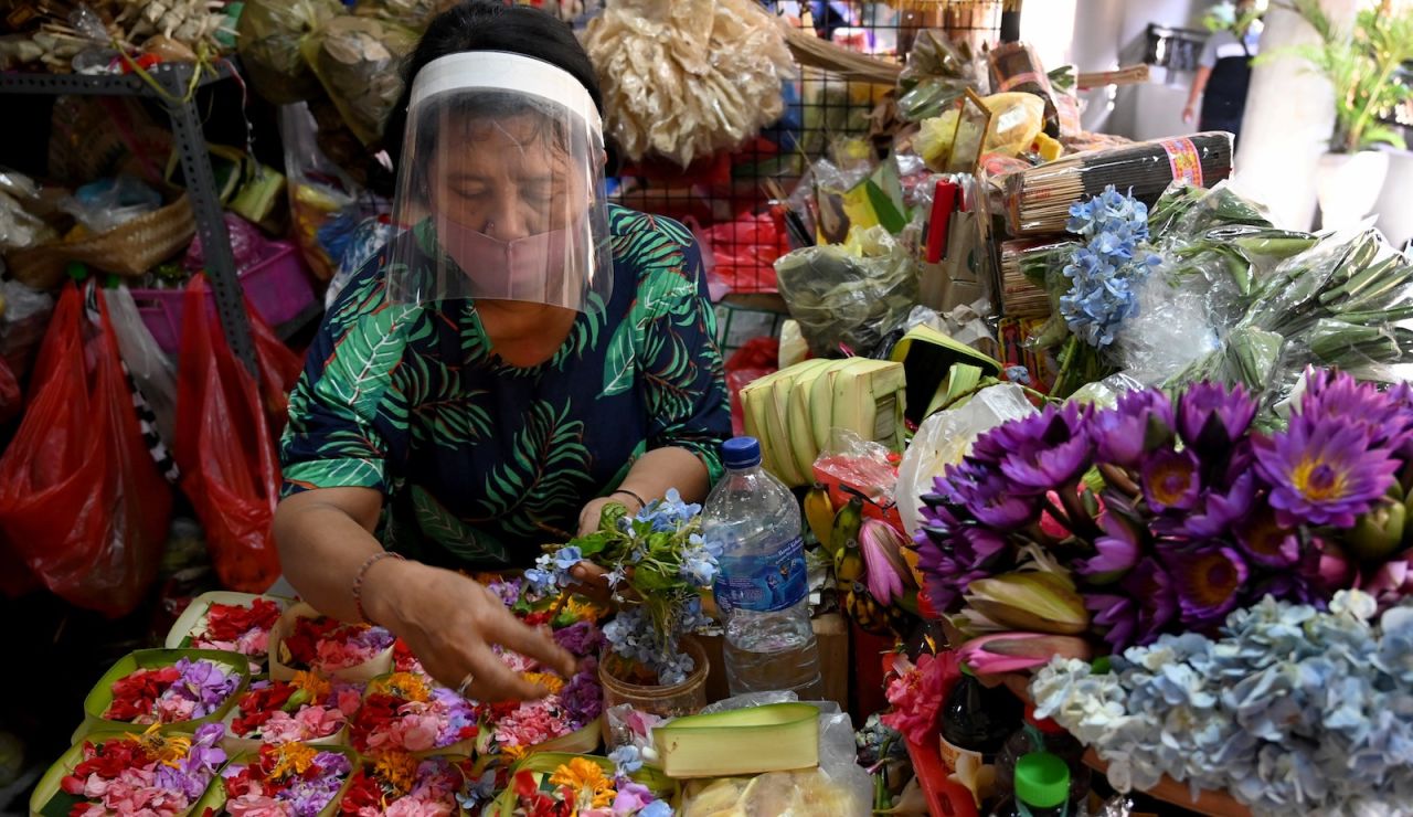 <strong>Covid-19 prevention:</strong> A vendor wearing a face shield makes religious offerings at a traditional market in Denpasar, Bali's capital. Currently, Bali shows signs of successfully flattening its Covid curve, with under 50 new cases per day for its population of around four million.