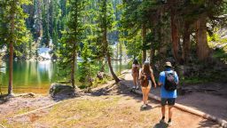 People hiking on Emerald Lake Trail, next to Dream Lake, Rocky Mountains National Park, Colorado, USA.