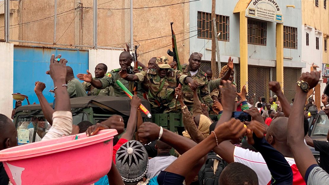 Malian soldiers are celebrated as they arrive at the Independence square in Bamako on August 18