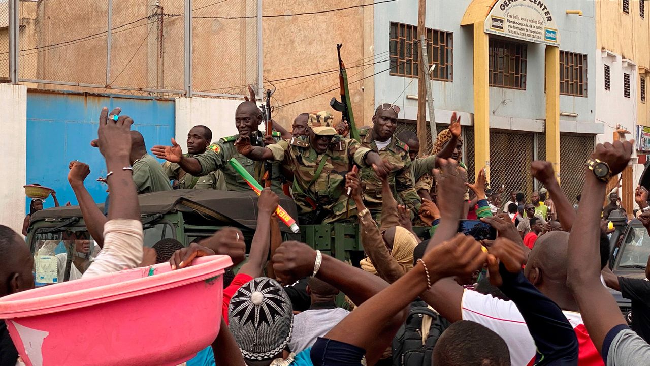 Malian soldiers are celebrated as they arrive at the Independence square in Bamako on August 18