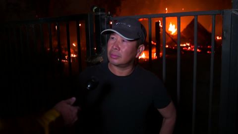 Thuy Ngo stands Wednesday in front of his burning barn near Vacaville.