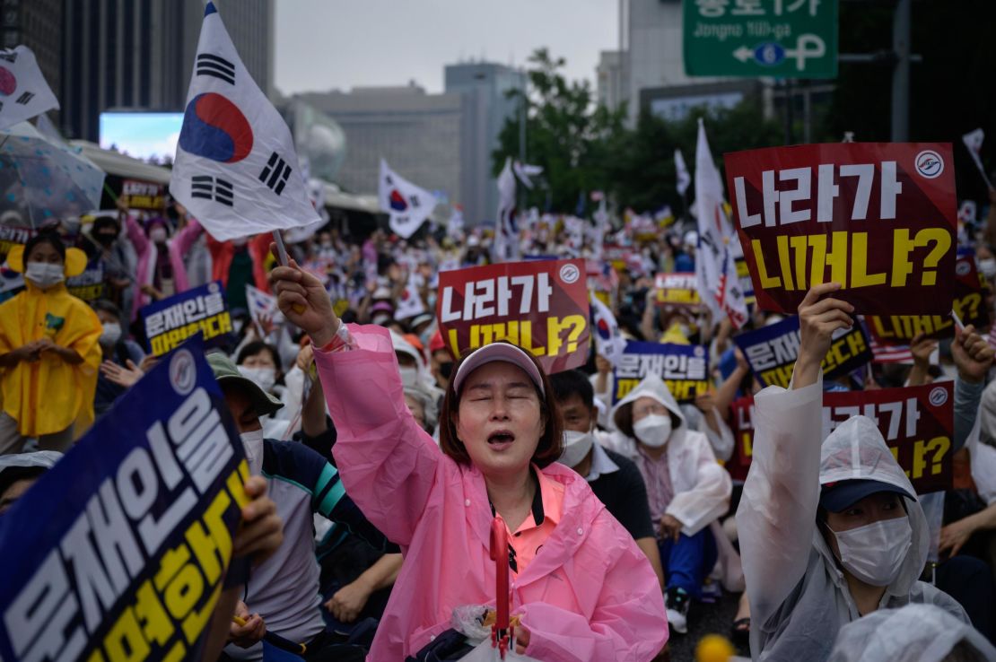 Members of conservative christian groups wave flags and shout slogans during an anti-government rally in the central Gwanghwamun area of Seoul on August 15, 2020. 