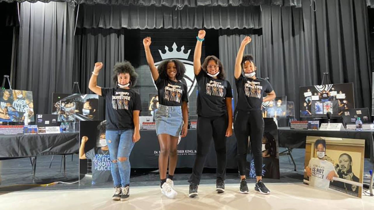 Students ask their schools to require Black history courses. From left: Alana Mitchell, Jenelle Nangah, Dahni Austin and Kaliah Yizar raise their arms in salute in front of their social justice podcast set. 