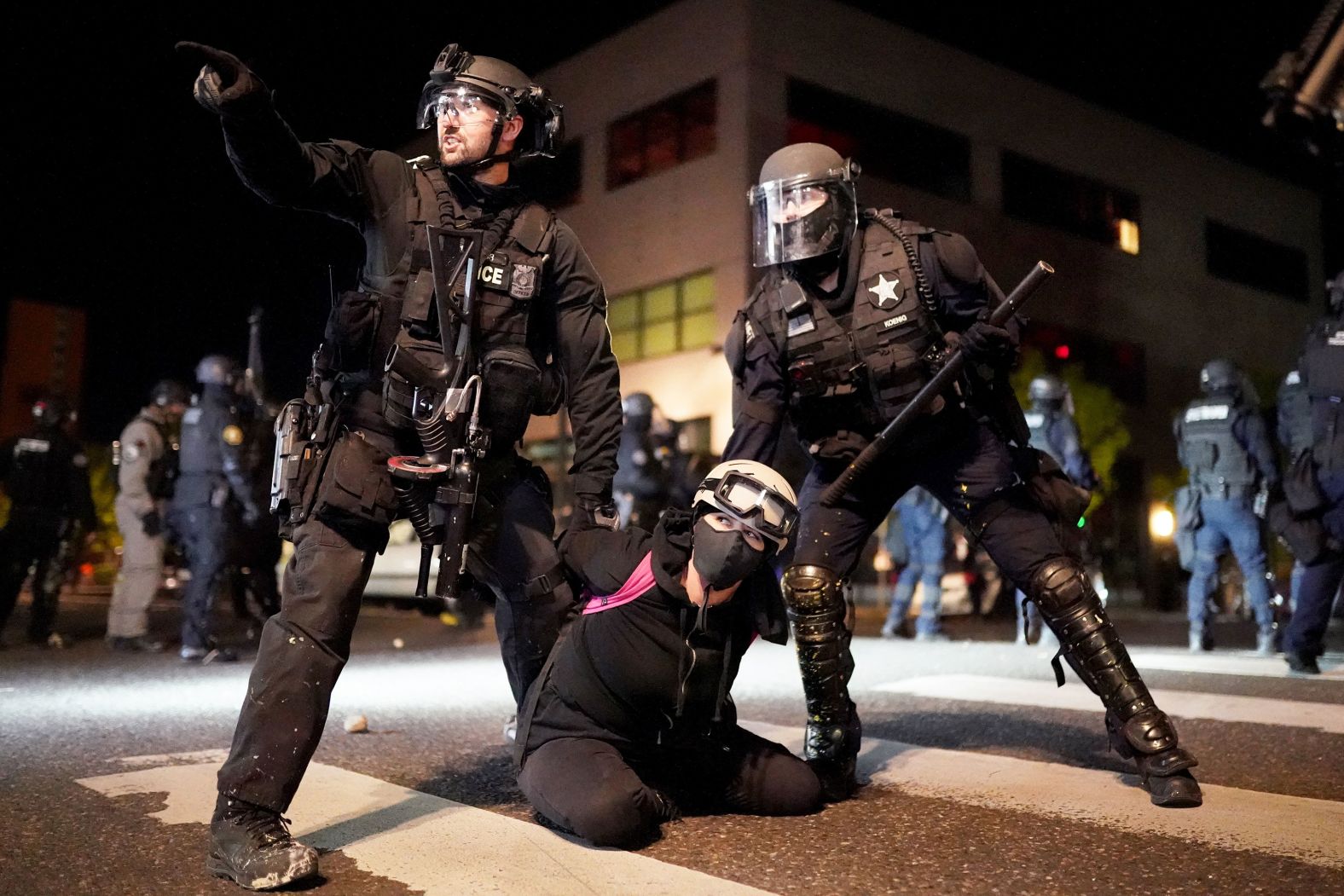 A protester is detained in front of the Portland Police Bureau's North Precinct on August 11.