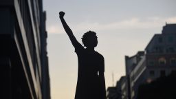TOPSHOT - A demonstrator's silhouette is seen as they raise a fist during a protest against police brutality and the death of George Floyd, near the White House on June 7, 2020 in Washington, DC. - On May 25, 2020, Floyd, a 46-year-old black man suspected of passing a counterfeit $20 bill, died in Minneapolis after Derek Chauvin, a white police officer, pressed his knee to Floyd's neck for almost nine minutes. (Photo by Olivier DOULIERY / AFP) (Photo by OLIVIER DOULIERY/AFP via Getty Images)