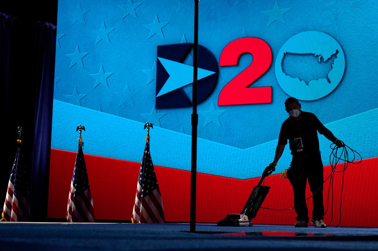 A worker vacuums the stage before Harris' speech on Wednesday.