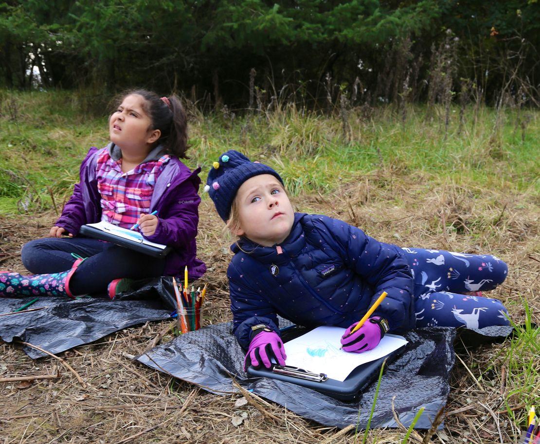 (From left) Roxinny Parra Salgado and Tilly Harris-Taylor observe, listen to and document the sights and sounds of the wetland environment of the Tualatin River outside of Cornelius, Oregon, as part of the curriculum at the Early Learning Community School at Pacific University.