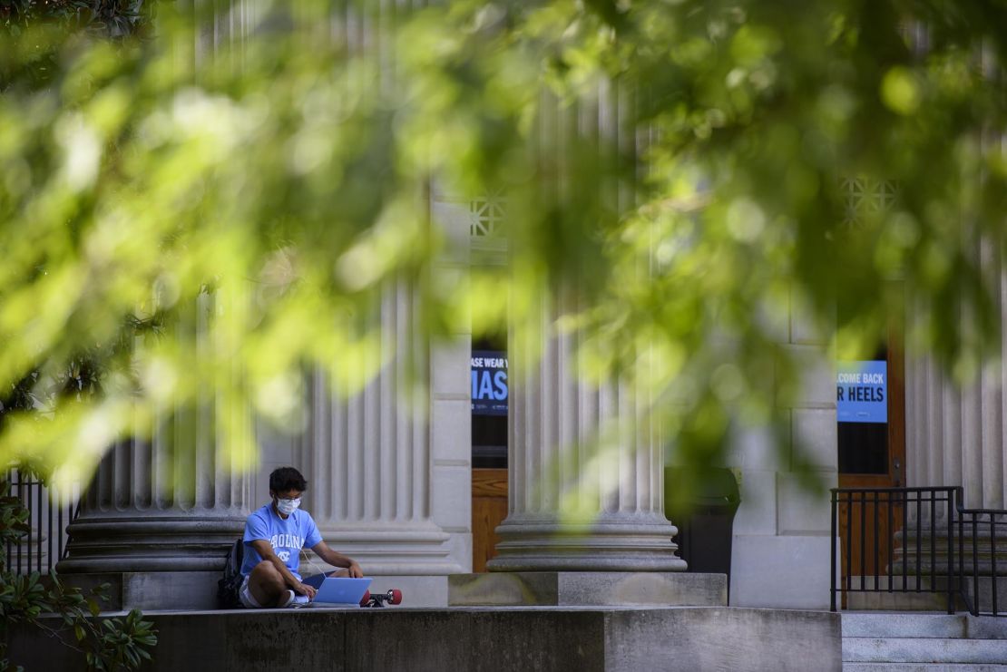 A student studies outside the closed Wilson Library on the campus of the University of North Carolina at Chapel Hill on August 18, 2020 in Chapel Hill, North Carolina. The school halted in-person classes and reverted back to online courses after a rise in the number of COVID-19 cases.
