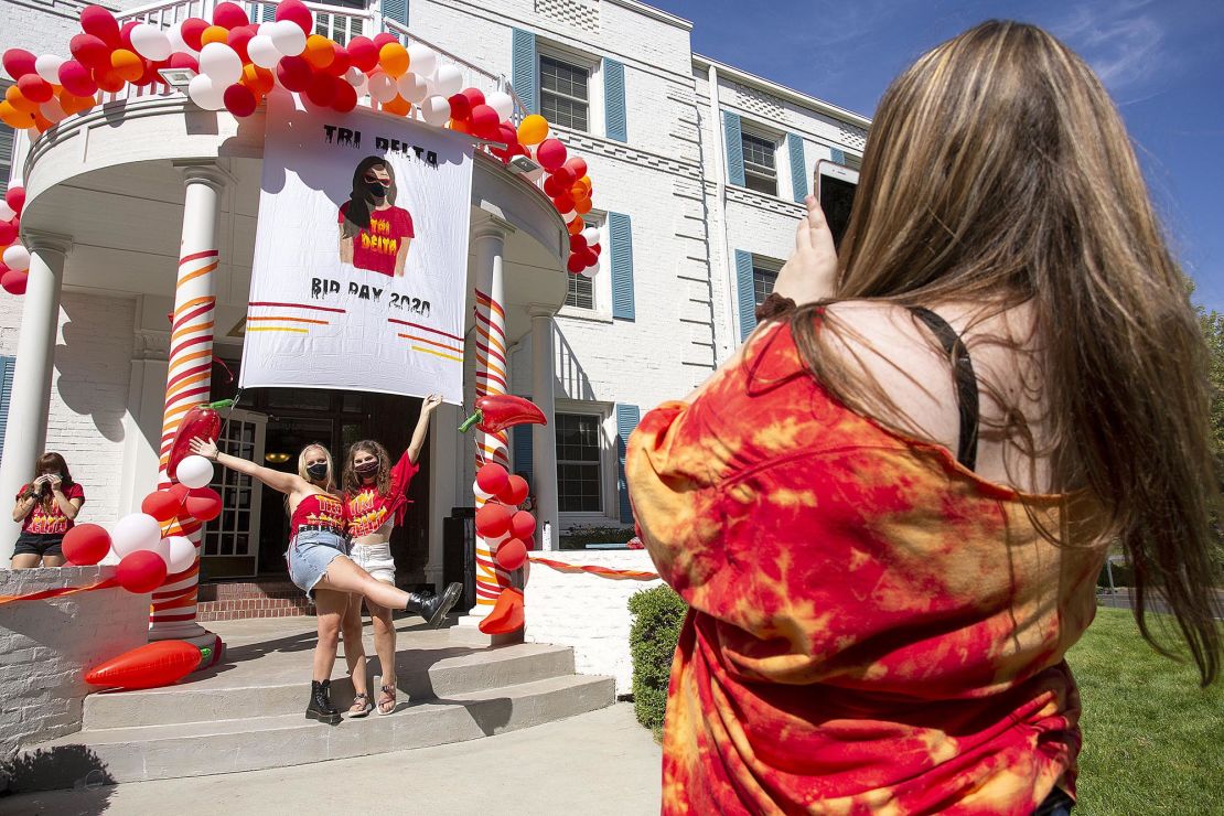 University of Idaho sophomore Natalie Talcott, right, photographs Ireland Neff, left, and Sage Huggins outside Delta Delta Delta sorority during sorority bid day, the final day of the recruitment process, on Monday, Aug. 17, 2020, in Moscow, Idaho. Sororities and fraternities at the university are taking a variety of precautions to help prevent the spread of the coronavirus. The first day of classes at the University are on Aug. 24. (Geoiff Crimmins/Moscow-Pullman Daily News via AP)