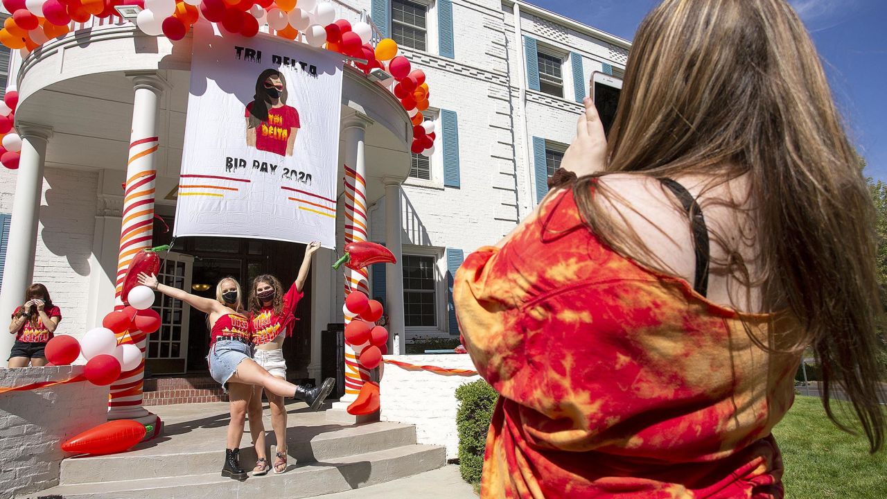 University of Idaho sophomore Natalie Talcott, right, photographs Ireland Neff, left, and Sage Huggins outside Delta Delta Delta sorority during sorority bid day, the final day of the recruitment process, on Monday, Aug. 17, 2020, in Moscow, Idaho. Sororities and fraternities at the university are taking a variety of precautions to help prevent the spread of the coronavirus. The first day of classes at the University are on Aug. 24. (Geoiff Crimmins/Moscow-Pullman Daily News via AP)