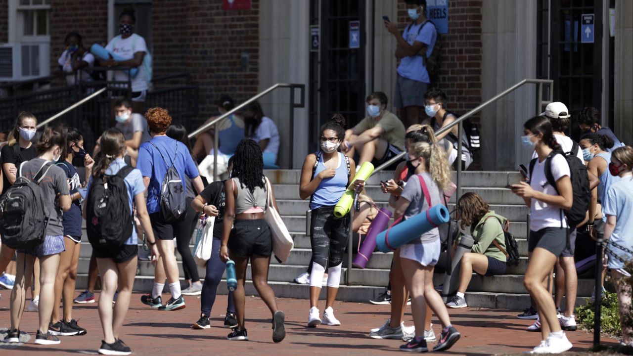 University of North Carolina students wait outside of Woolen Gym on the Chapel Hill, N.C., campus as they wait to enter for a fitness class Monday, Aug. 17, 2020. The University announced minutes before that all classes will be moved online starting Wednesday, Aug. 19 due to COVID clusters on campus. (Julia Wall/The News & Observer via AP)