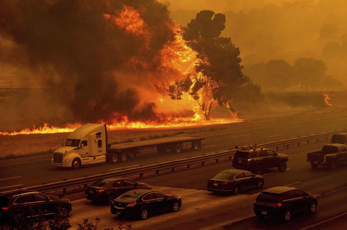 Flames from the LNU Lightning Complex fires jump Interstate 80 in Vacaville, California.