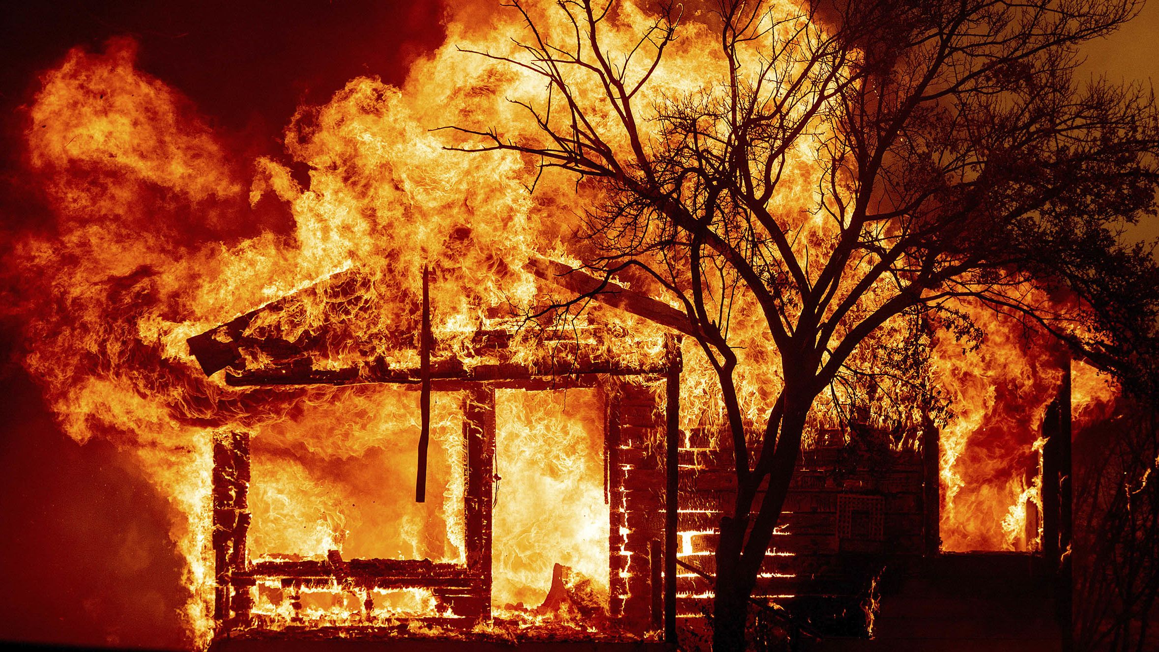 Flames from the LNU Lightning Complex fires consume a home Wednesday in Vacaville, California.