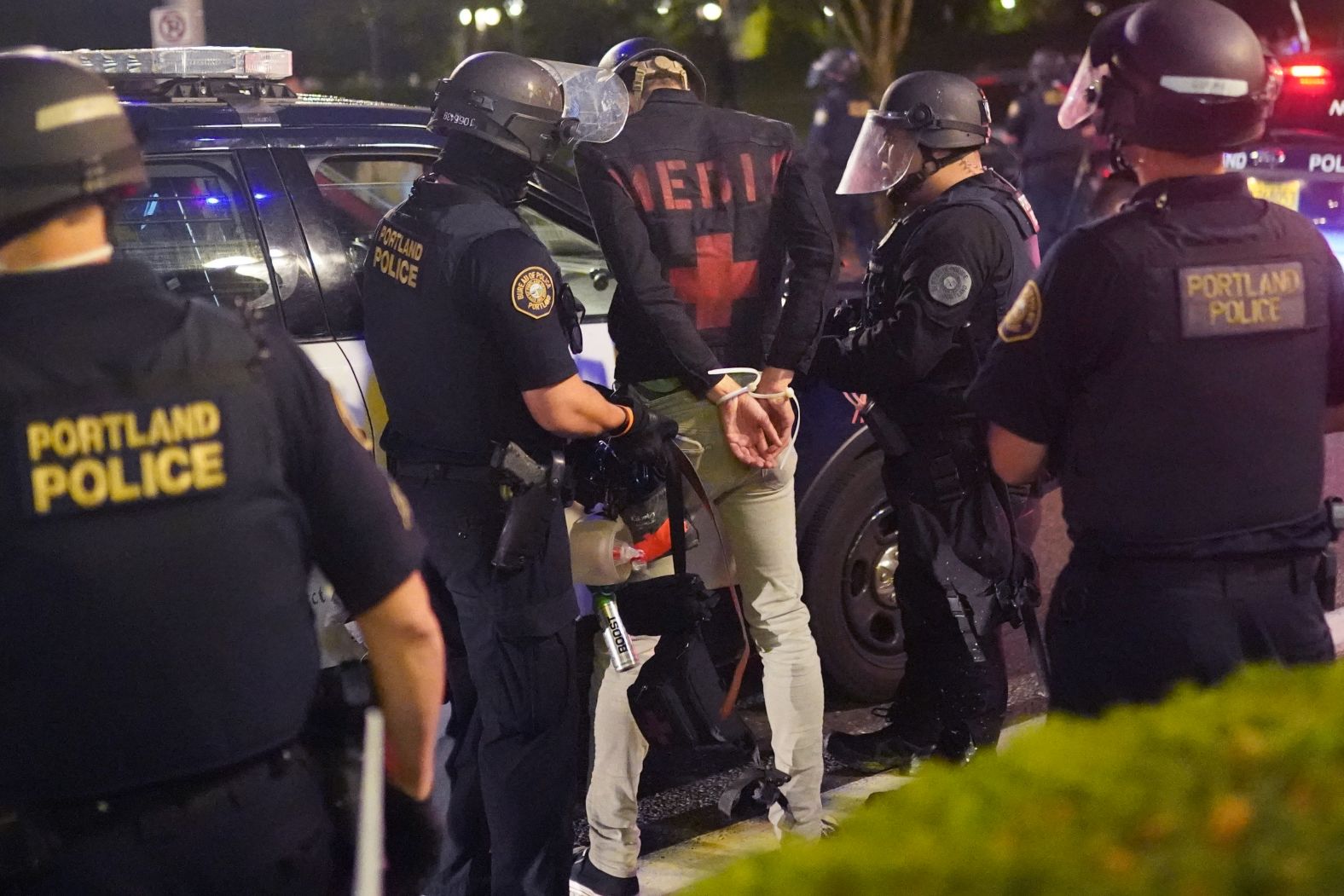 Portland police officers arrest a man said to be a street medic during a dispersal outside the Immigration and Customs Enforcement (ICE) detention facility on August 21.