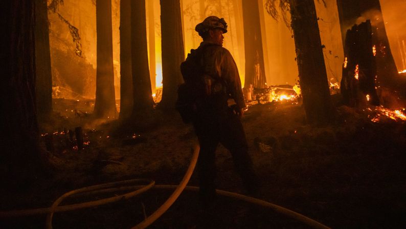 A firefighter battles flames in Santa Cruz County, California, on August 20, 2020.