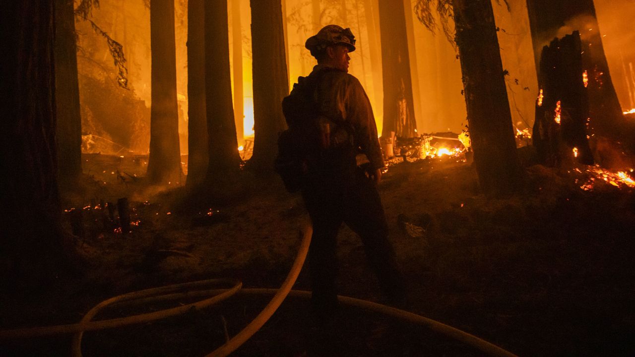 A firefighter battles flames in Santa Cruz County, California, on August 20.