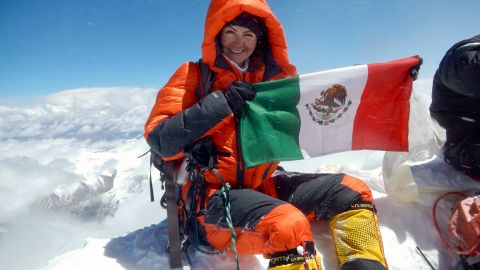 Viridiana Álvarez Chávez holds up a Mexican flag at the top of Mount Everest.