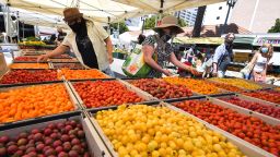 People wearing face coverings shop for tomatoes at the Santa Monica Farmers' Market in Santa Monica, California, August 1, 2020 during the coronavirus pandemic.