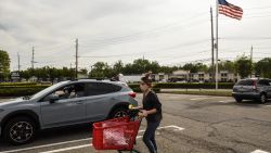 An employee of Michaels retail store delivers an order to a customer waiting outside in their car on May 18, 2020 in Paramus, New Jersey. New Jersey is allowing non-essential retail stores to reopen for curbside pickup service only. (Photo by Stephanie Keith/Getty Images)