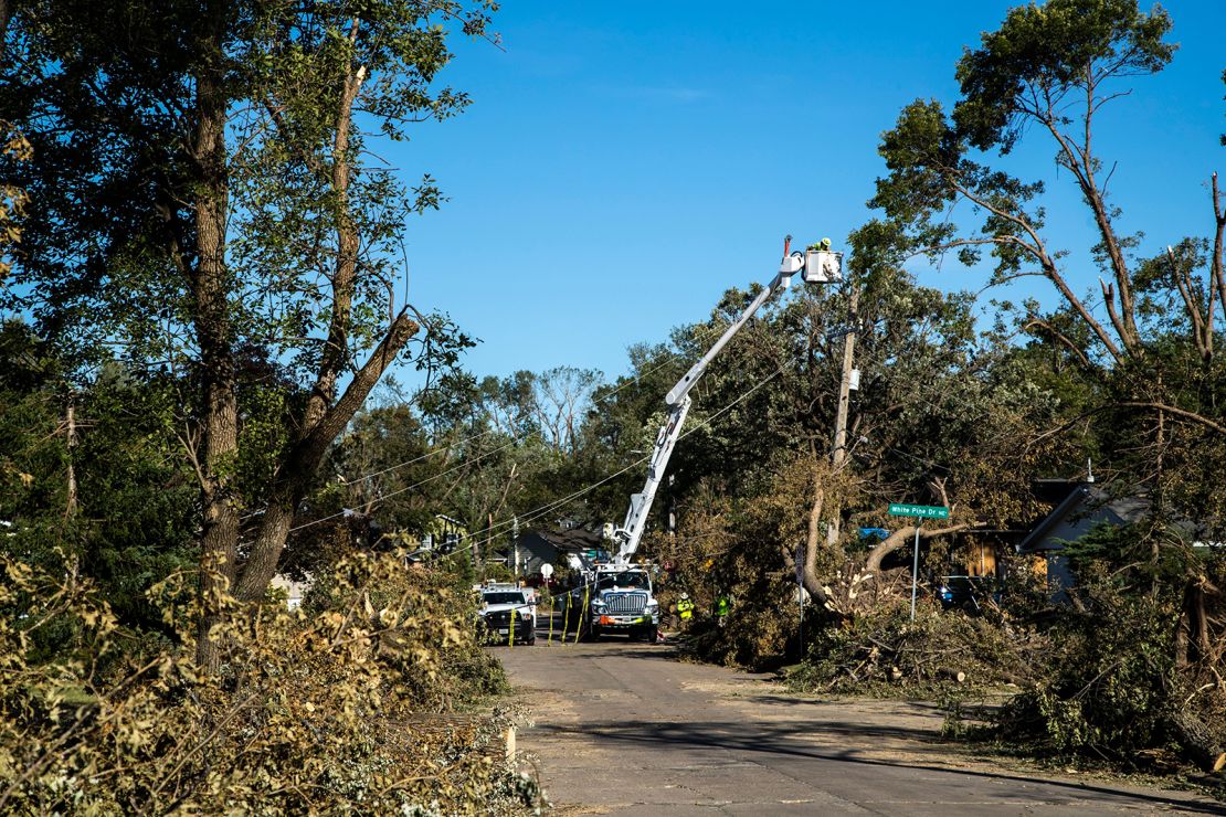 Tree branches pile up along the street as power line crews with Alliant Energy work to repair electrical lines on  Tuesday, August 18, 2020, in Cedar Rapids, Iowa.