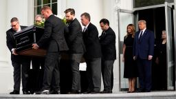 President Donald Trump and first lady Melania Trump hold hands as they watch people carry the casket of Robert Trump out of the White House after a memorial service for the president's younger brother on Friday, Aug 21, 2020.