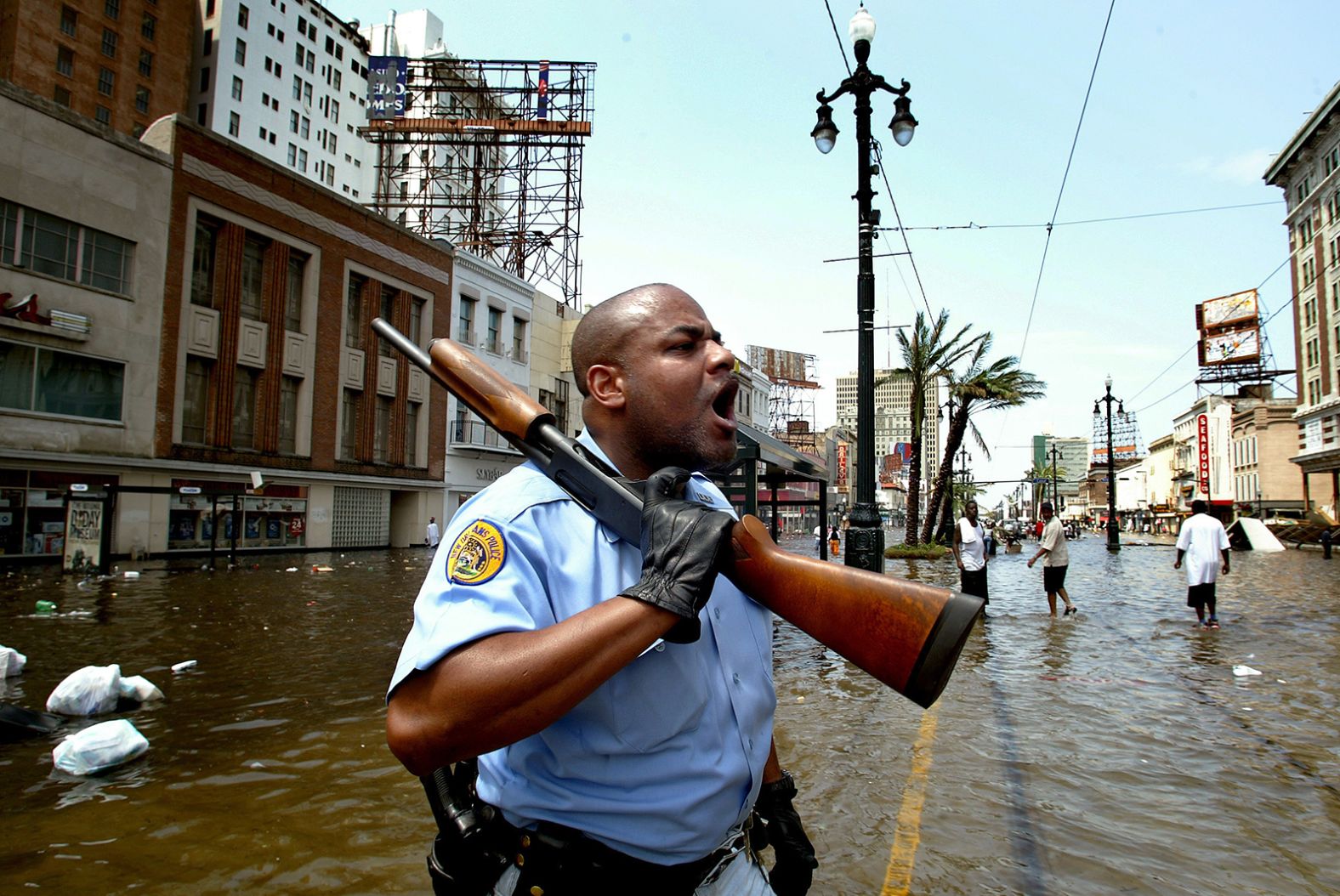 New Orleans police officer Mark Wilson yells at people in stores looters on Canal Street. In Katrina's aftermath, many questioned whether some people accused of looting were just people scavenging for the supplies they needed to survive.