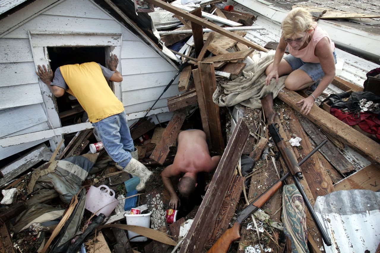 From left, Tam Cu, Jason Jackson and Linda Bryant look for belongings from Bryant's home, which was devastated in Biloxi, Mississippi.