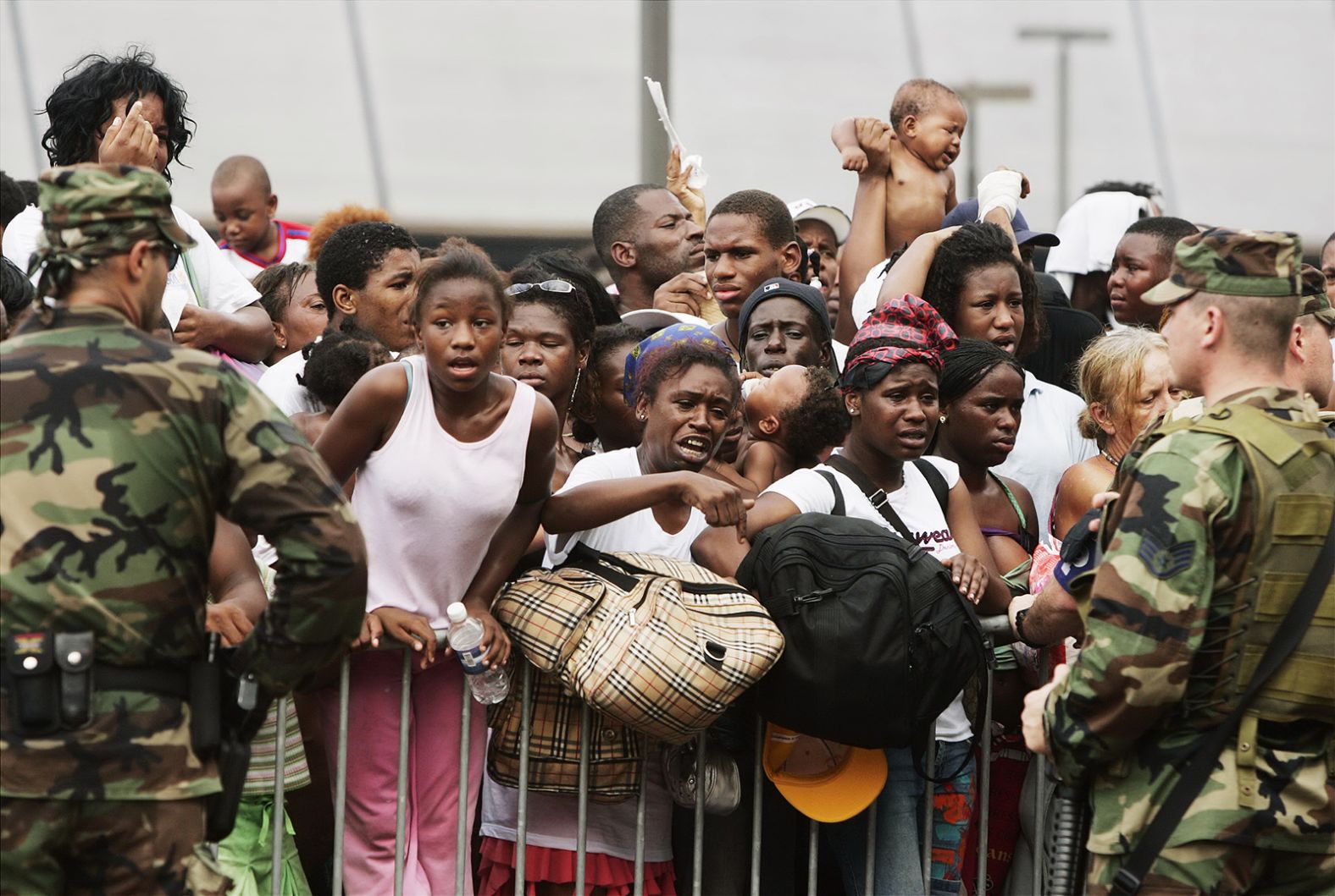 Members of the National Guard stand outside the Superdome as emotional evacuees await their next destination.