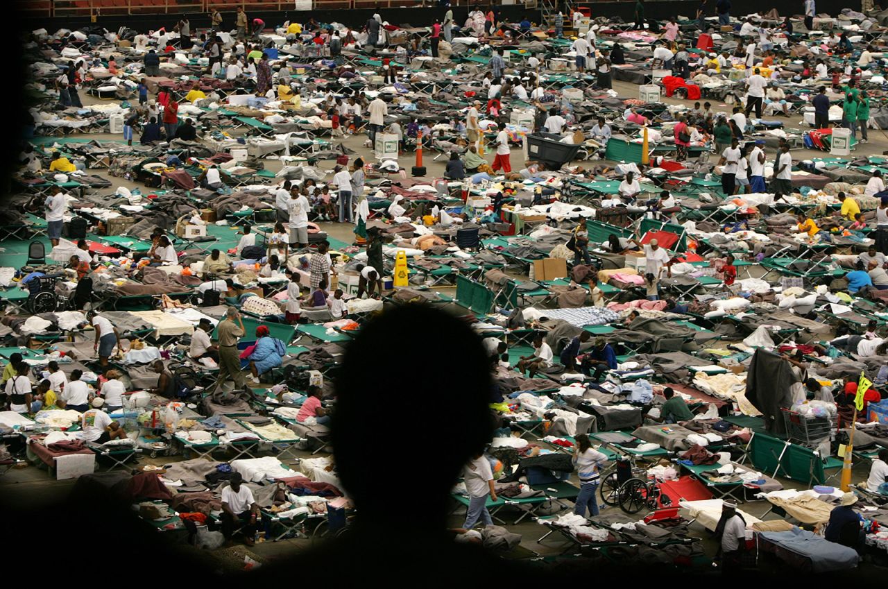 A man in the foreground looks at Katrina evacuees who received food, shelter and medical attention at the Astrodome in Houston.