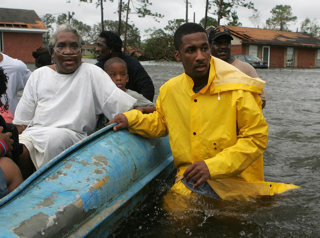 Police officer Terrence Gray helps Lovie Mae Allen and group of children evacuate their flooded homes in Gulfport, Mississippi.