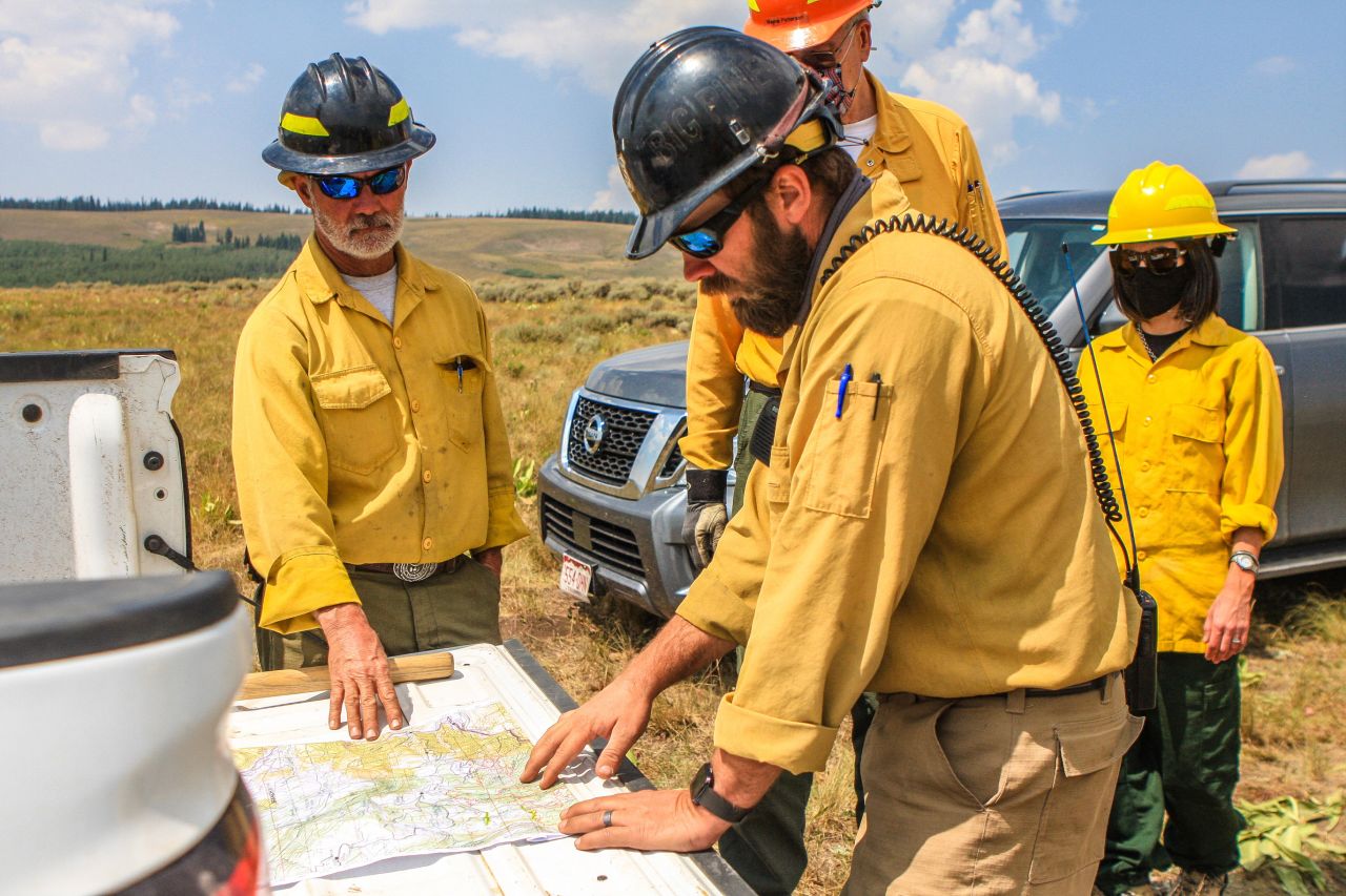 Members of the US Forest Service discuss their next moves to battle the Grizzly Creek Fire near Dotsero, Colorado, on August 21, 2020.