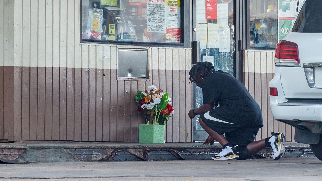 A man kneels to say a prayer outside convenience store on Evangeline Thruway where a man was shot and killed by Lafayette Police. Saturday, Aug. 22, 2020.