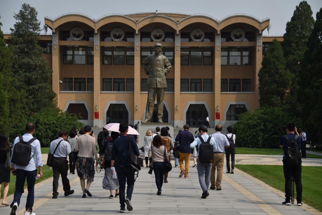 Students walk towards a statue of the late Chairman Mao Zedong at the Central Party School in Beijing.