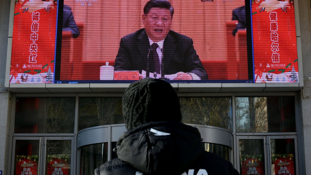 A man stands and watches a large screen during President Xi Jinping's speech commemorating the 40th anniversary of China's policy of reform and opening on December 18, 2018.