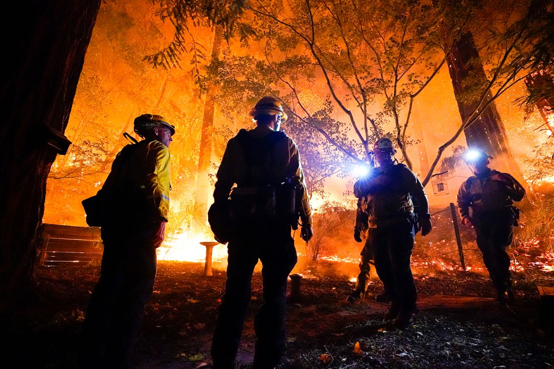 Firefighters make a stand in the backyard of a home in front of the advancing CZU August Lightning Complex Fire on Friday, August 21, in Boulder Creek, California.