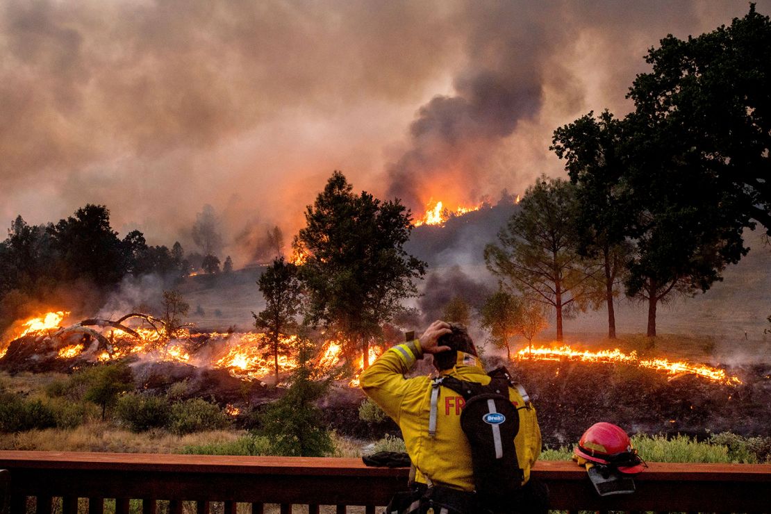 A firefighter rubs his head while watching the LNU Lightning Complex fires spread through the Berryessa Estates neighborhood of unincorporated Napa County, California, on Friday, August 21.