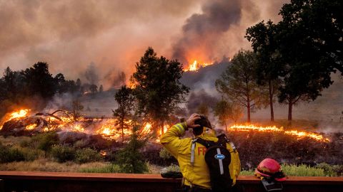A firefighter rubs his head while watching the LNU Lightning Complex fires spread through the Berryessa Estates neighborhood of unincorporated Napa County, California, on Friday, August 21.