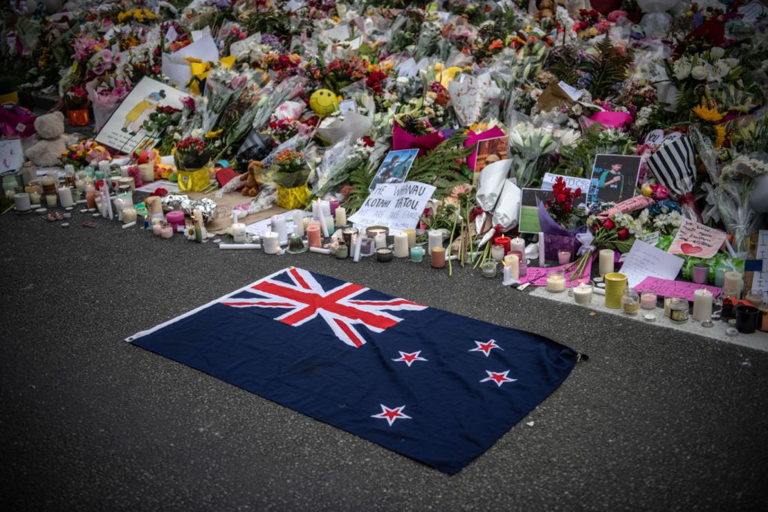 A New Zealand flag is placed next to flowers and tributes near Al Noor Mosque on March 18, 2019 in Christchurch, New Zealand. 