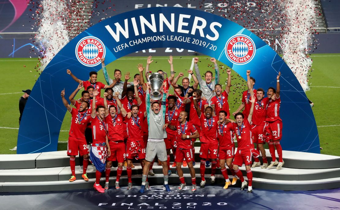 Bayern captain Manuel Neuer lifts the Champions League trophy in front of his team.