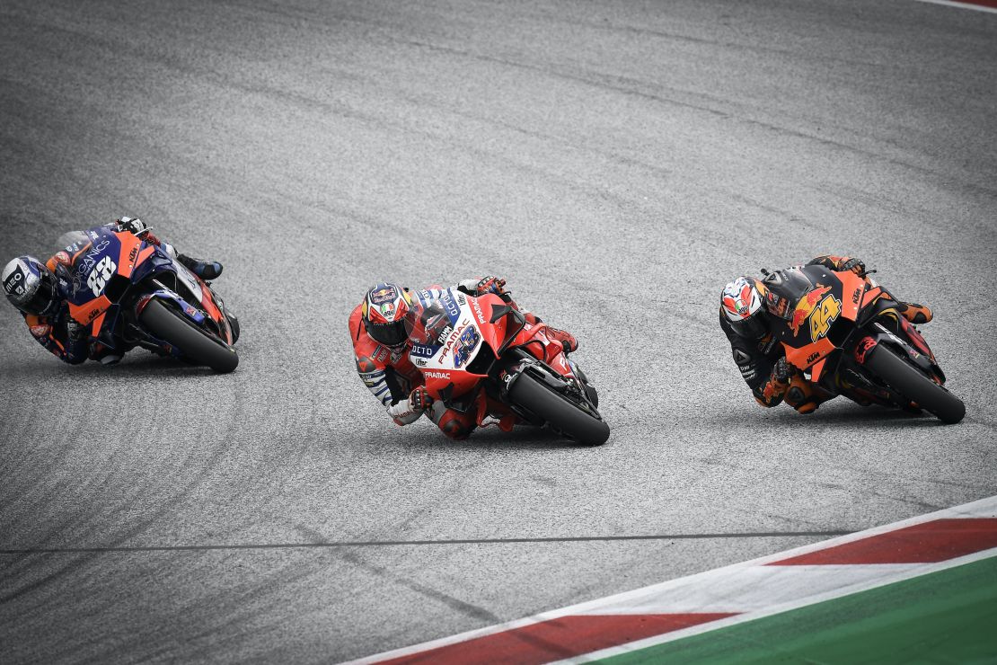 Oliveira (left) overtakes Espargaro (right) and Miller on the final corner for victory.