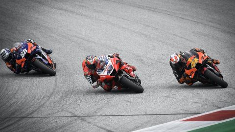 Oliveira (left) overtakes Espargaro (right) and Miller on the final corner for victory.