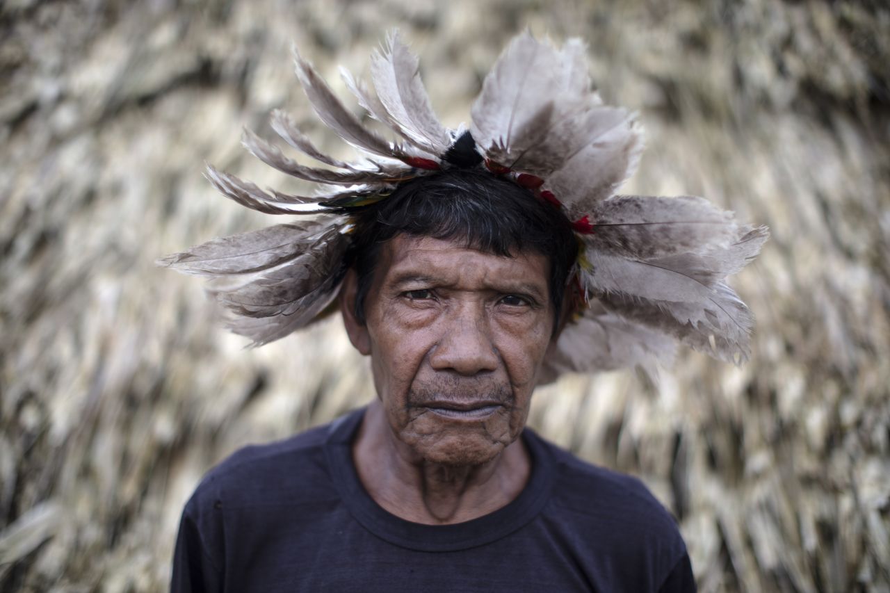 Tari Uru Eu Wau Wau, a member of the tribe. The men wear headdresses made with parrot, macaw and eagle feathers.