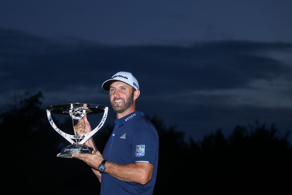 Johnson celebrates with the trophy after winning The Northern Trust.