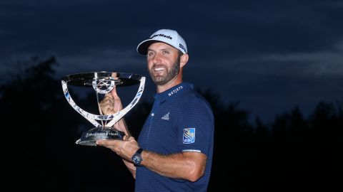 Johnson celebrates with the trophy after winning The Northern Trust.