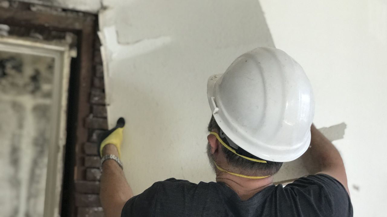 A contractor removes drywall from a home being repaired with donations from Rebuilding Together.